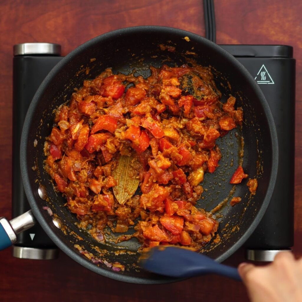 Adding chopped tomato and sauteing