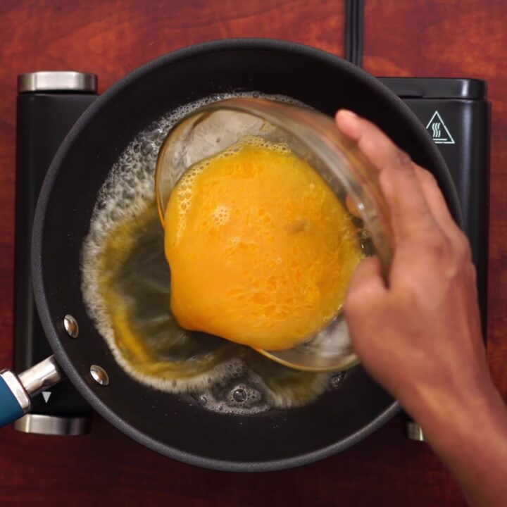 adding butter and beaten eggs into a pan