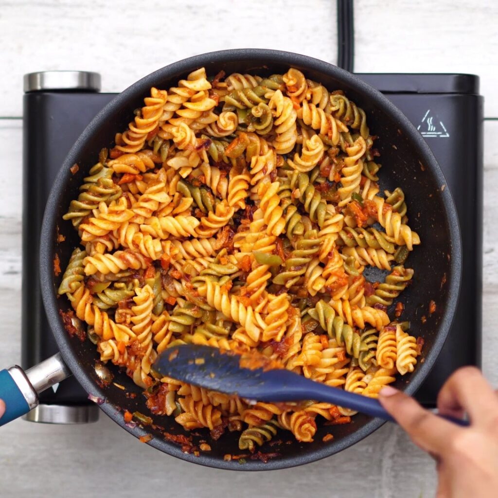 Adding cooked pasta and coating evenly