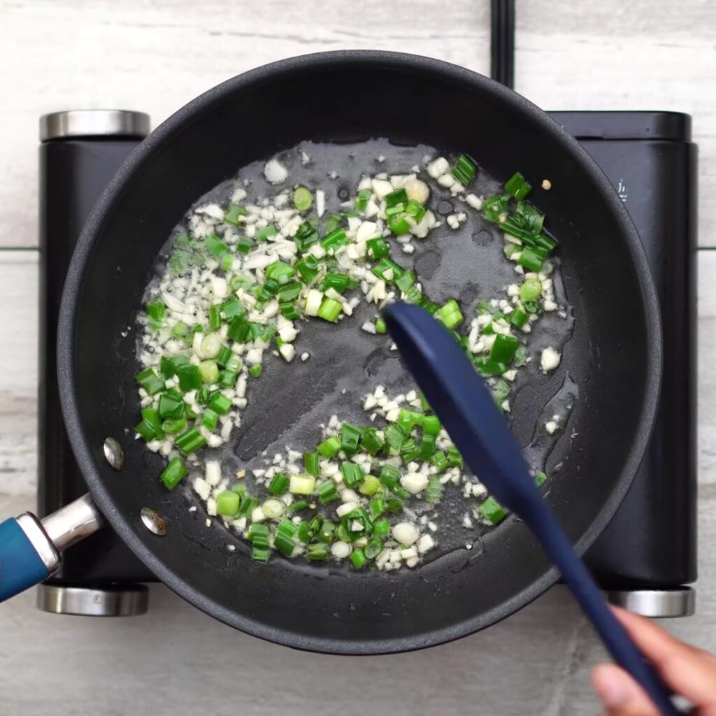 adding garlic and spring onion in oil