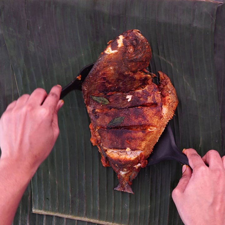 Placing the fish on banana leaf with masala