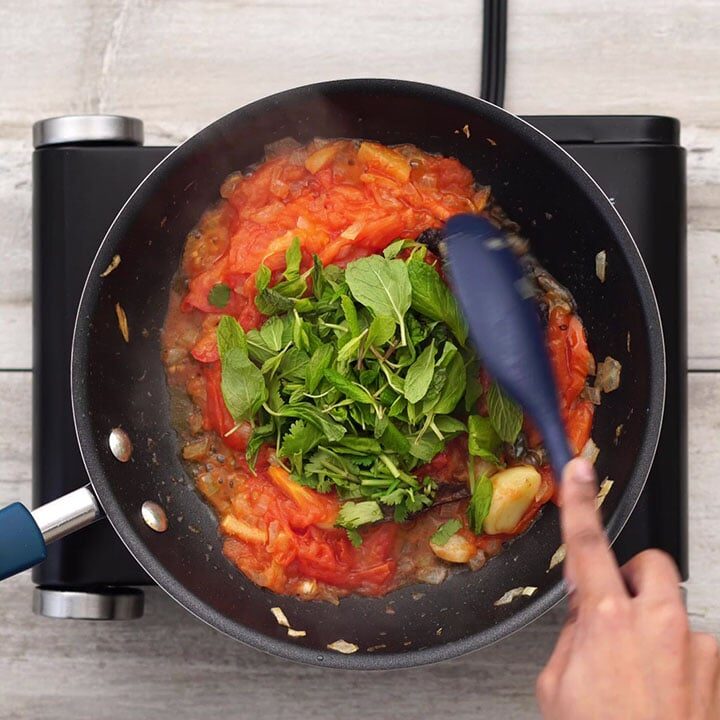 Adding tomato, leaves and sauteing