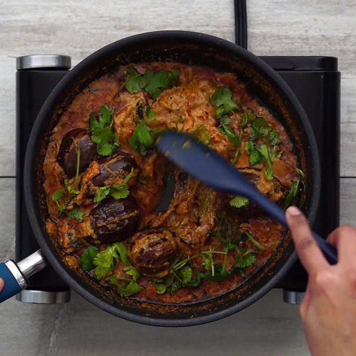Garnishing the curry with coriander leaves