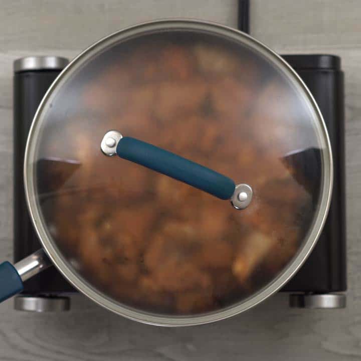 chicken is cooking in a pan with its lid closed