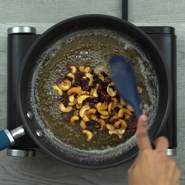 mixing fried nuts and cardamom powder