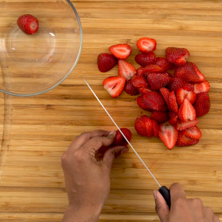 Cutting strawberries into small pieces.