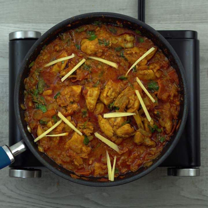 chicken karahi garnished with ginger and coriander leaves