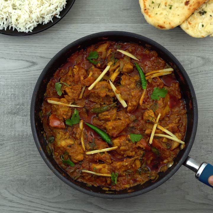 serving chicken karahi or kadai chicken with naan and rice