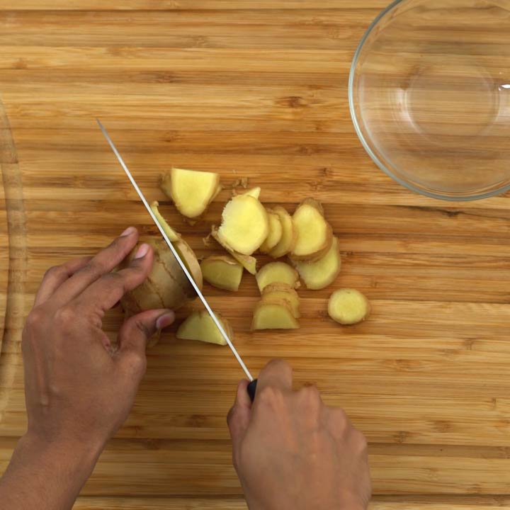 Slicing ginger roots into pieces.