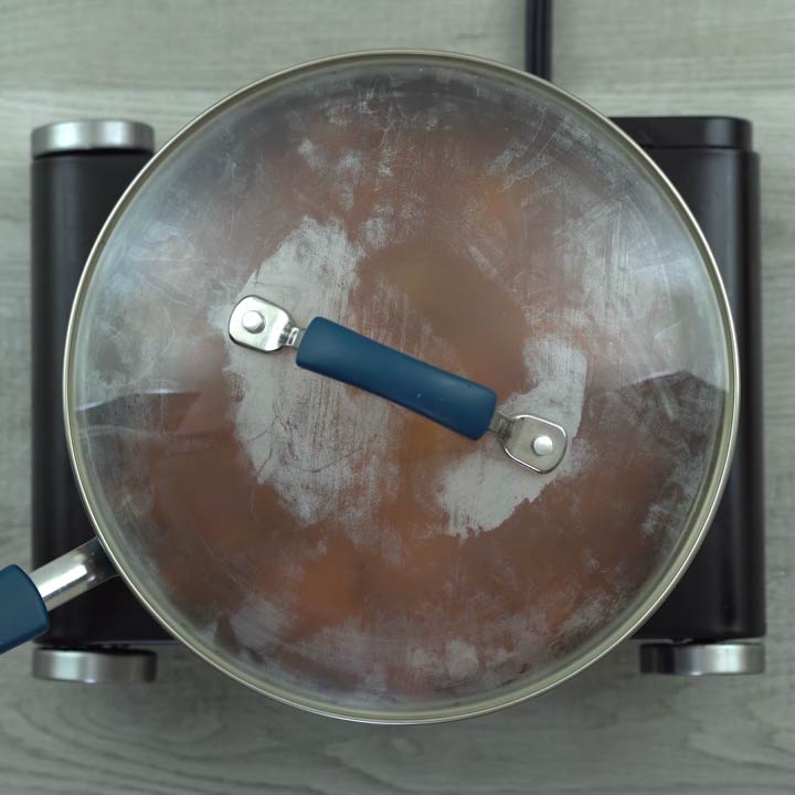 cooking lamb mixture with pans lid closed