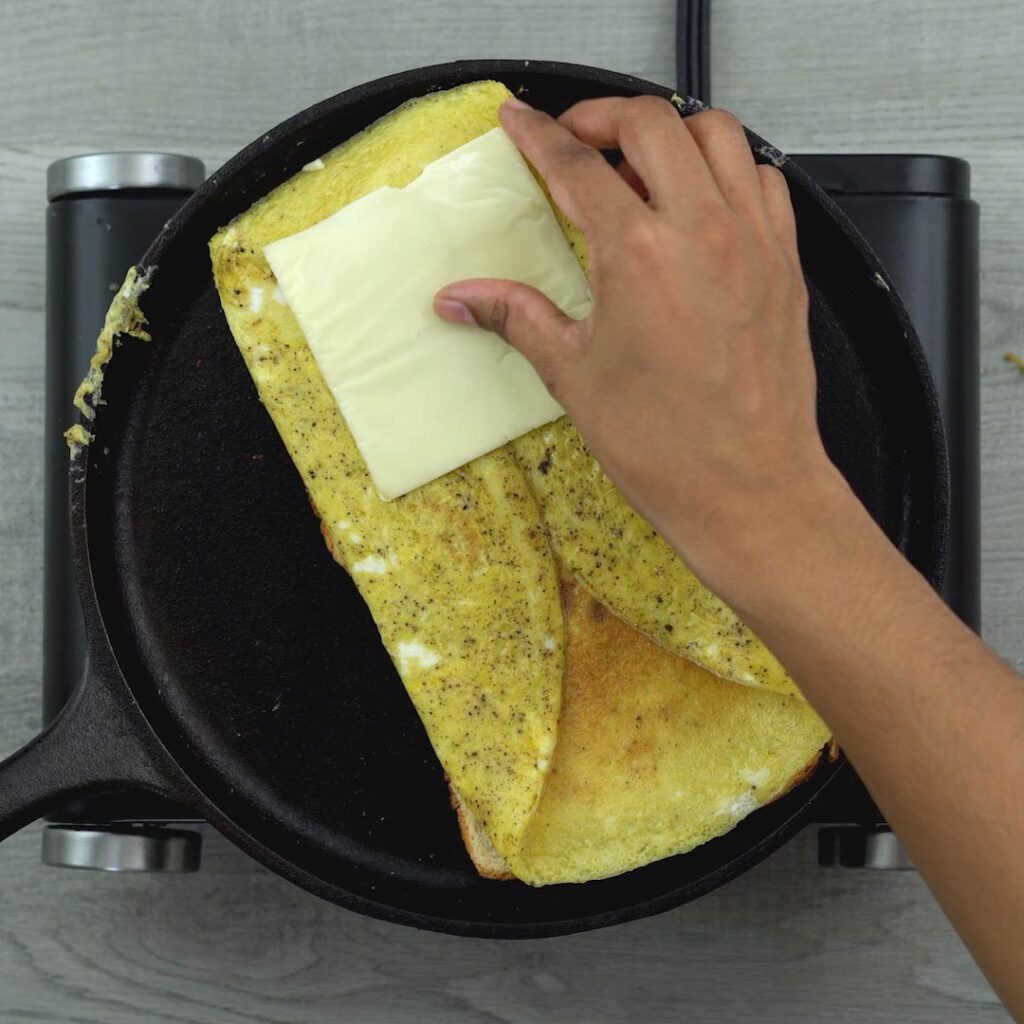 placing cheese on the bread omelet