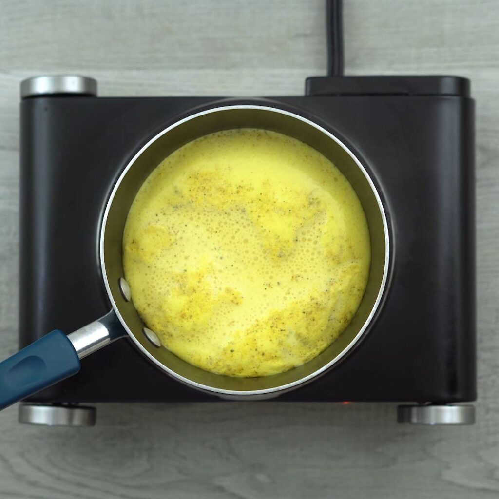 Golden Milk puffing up in a saucepan.