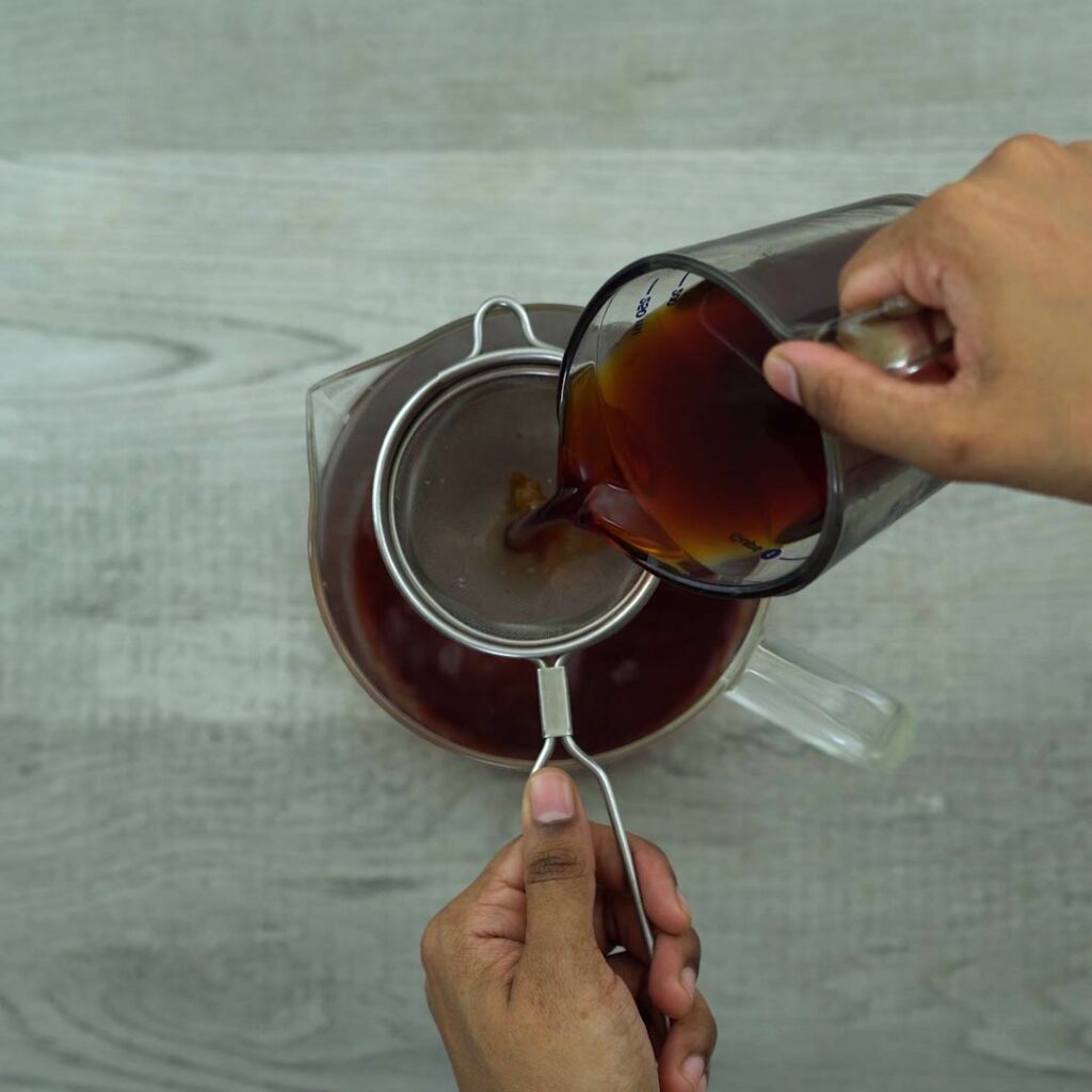 Filtering the tea using strainer.