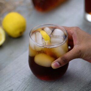 Serving Iced Tea with lot of ice cubes and lemon slice.