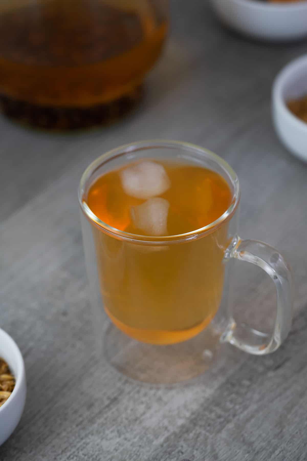 Barley Tea served with ice cubes with roasted barley kernels nearby.