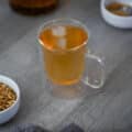 Barley Tea served with ice cubes with roasted barley kernels near by.