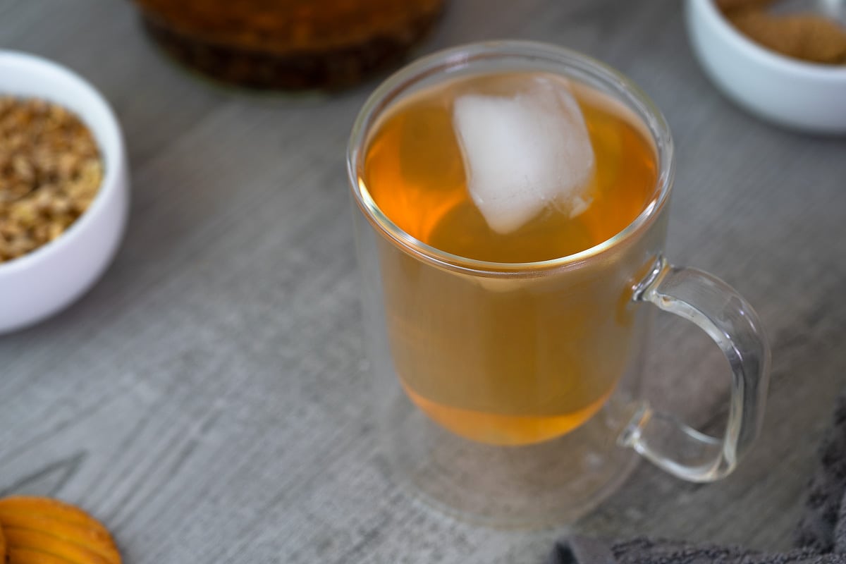 Barley Tea served with ice cubes with roasted barley kernels nearby.