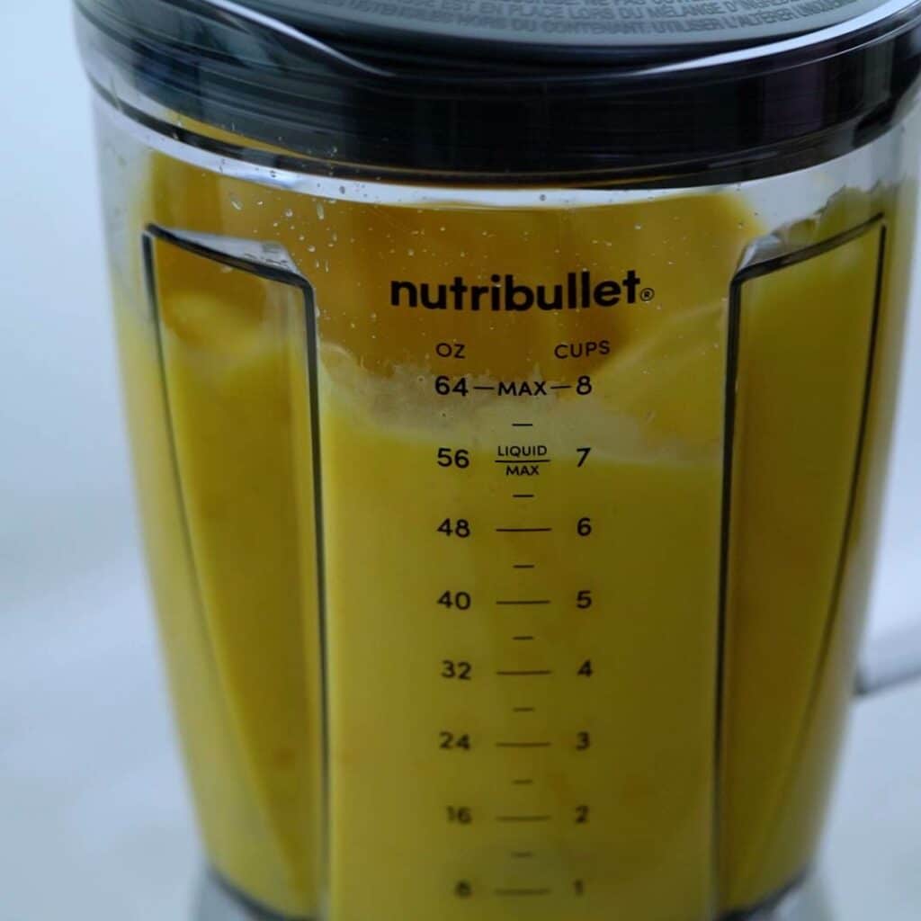 Mango juice is blending in blender.