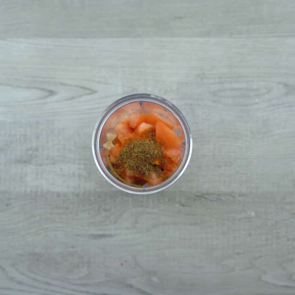 onion, tomatoes and spice powders in a blender