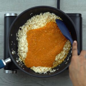 Mixing tomato spice mix to rice