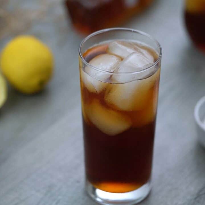 Sweet tea is served with a lot of ice cubes in a serving glass.
