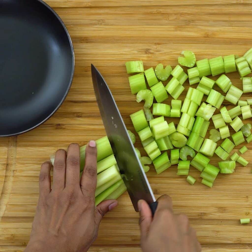 Cutting the celery into small pieces.