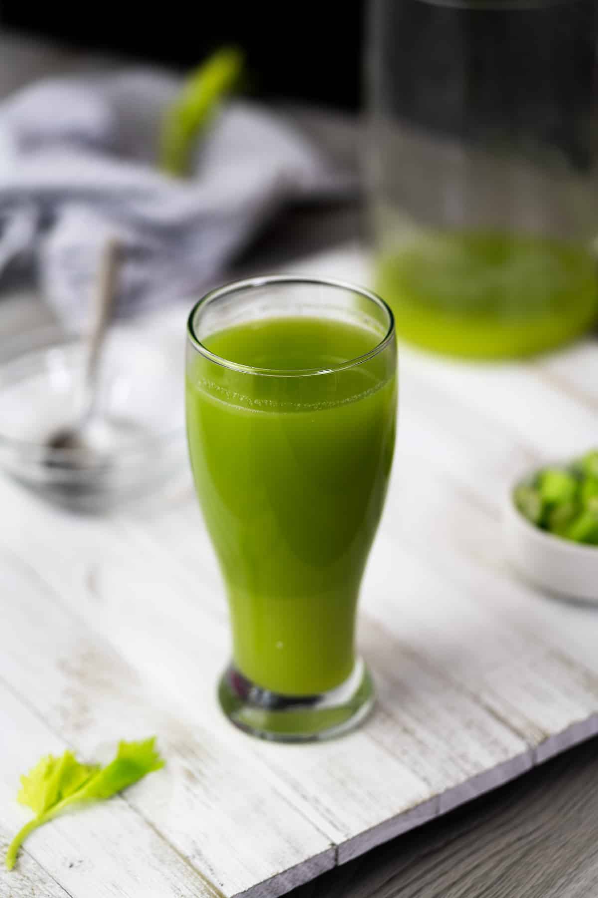 Celery Juice served in a glass with chopped celery in a bowl.