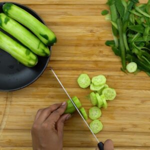 Chopping the peeled cucumber.
