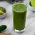 Cucumber Juice in a serving glass with cucumber placed nearby.