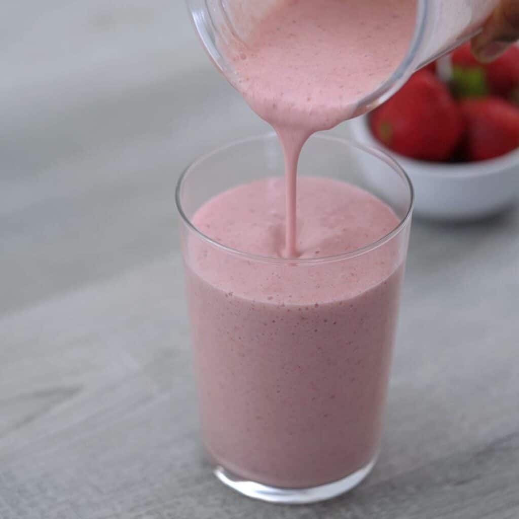 Pouring the Strawberry Banana Smoothie over a glass.