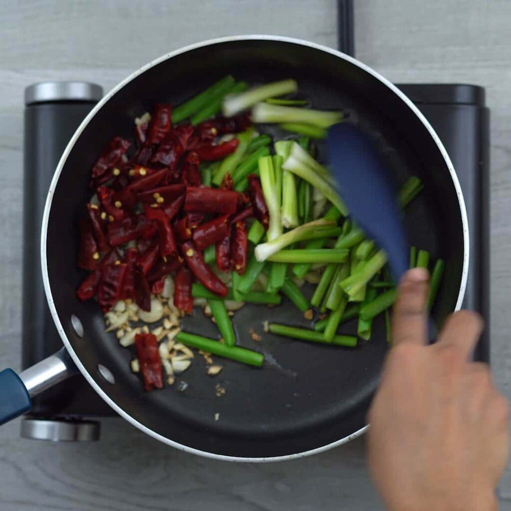 stirfrying the chili, spring onions, garlic and ginger