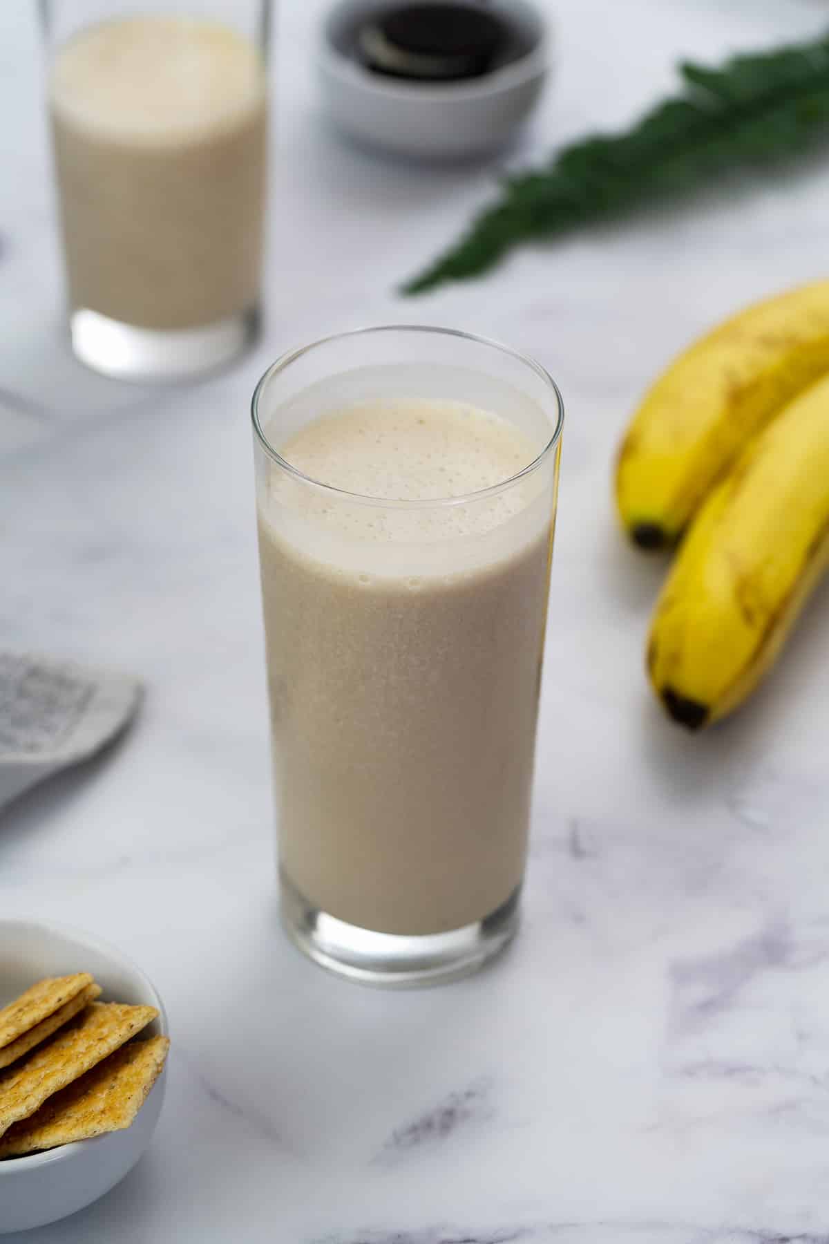 Banana Protein Shake served in a glass with banana placed nearby.