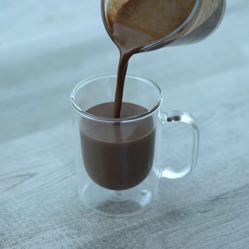 Pouring hot chocolate to serving glass.