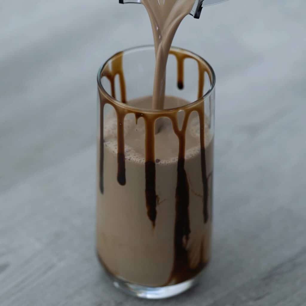 Pouring Chocolate milkshake into the serving glass.