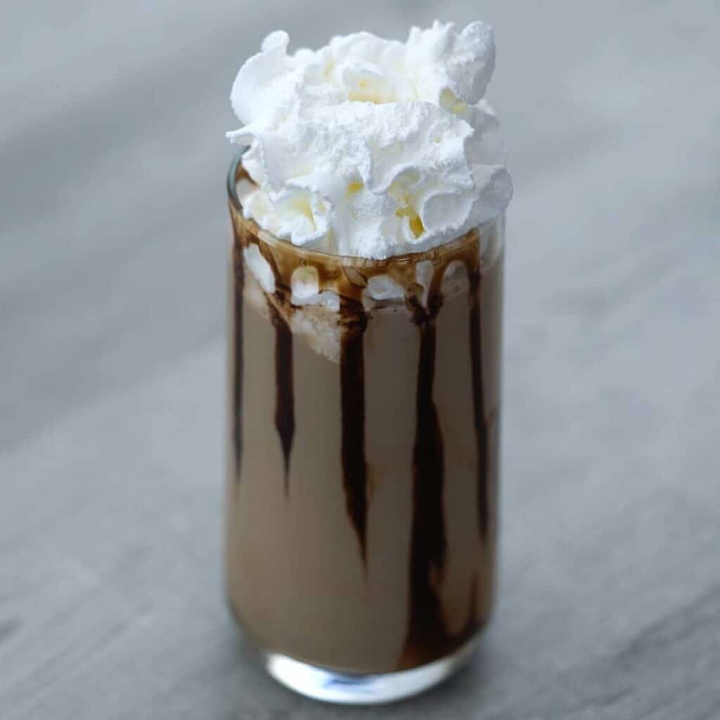 Chocolate milkshake topped with whipping cream.