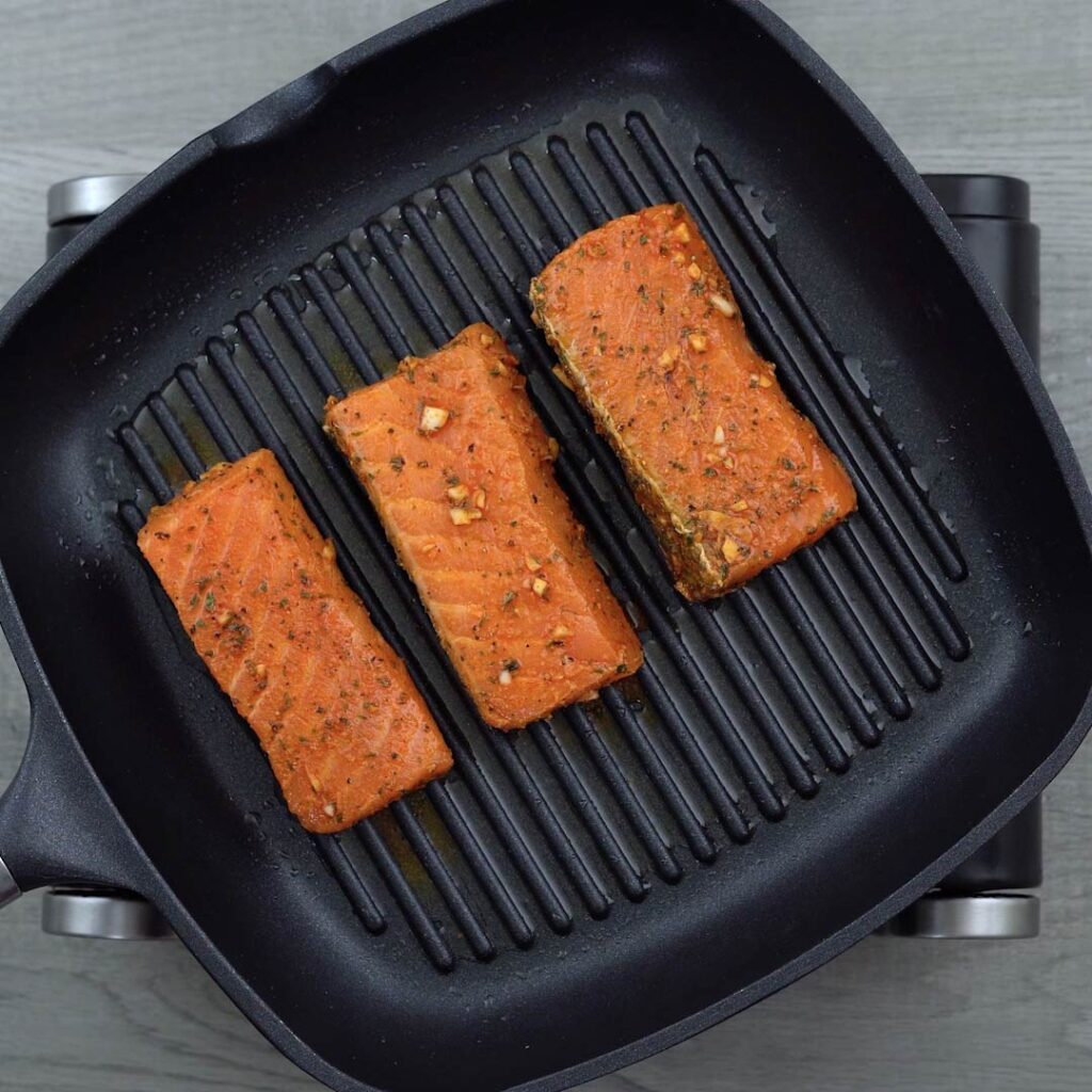 salmon is cooking in grilling pan