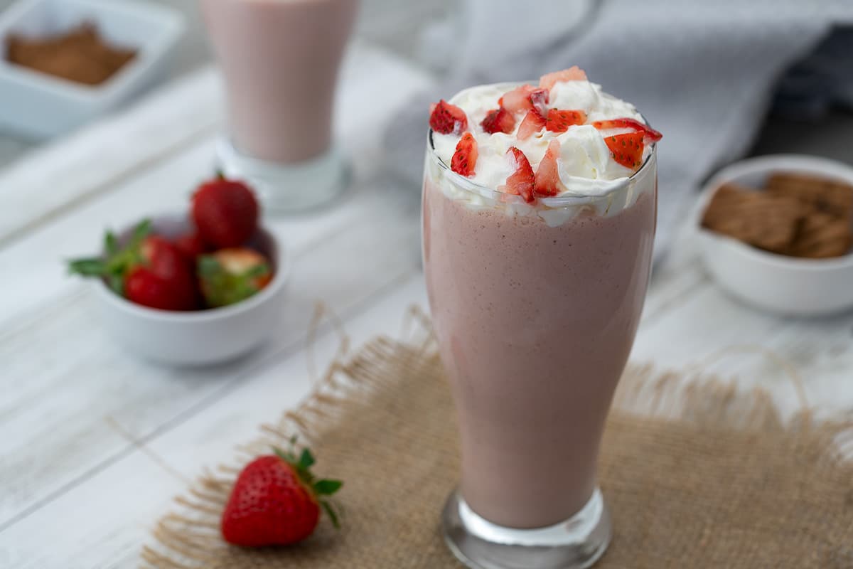 Strawberry Milkshake topped with whipping cream and strawberries.