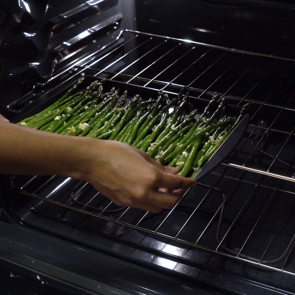 placing asparagus in oven to cook