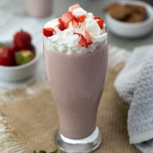 Strawberry Milkshake topped with whipping cream and strawberries.