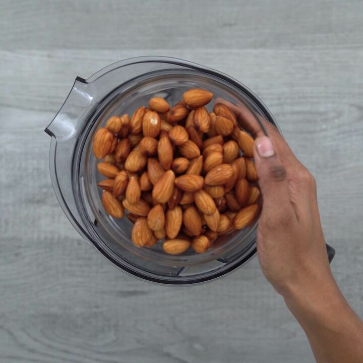 Adding soaked almonds in blender jar.