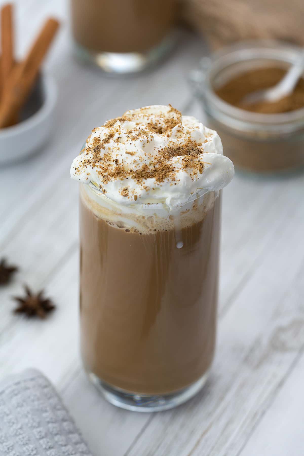 Dirty Chai Latte served in a glass with chai masala powder nearby.