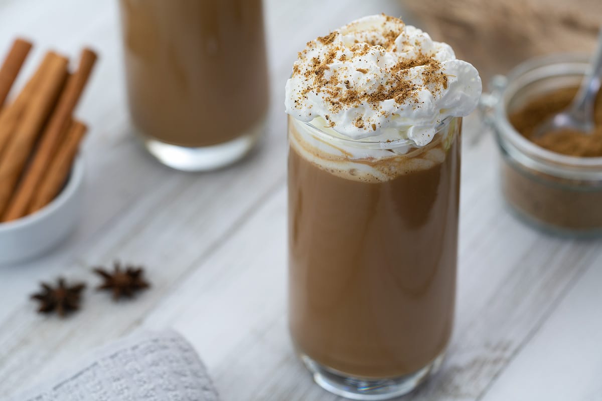 Dirty Chai Latte served in a glass with chai masala powder nearby.