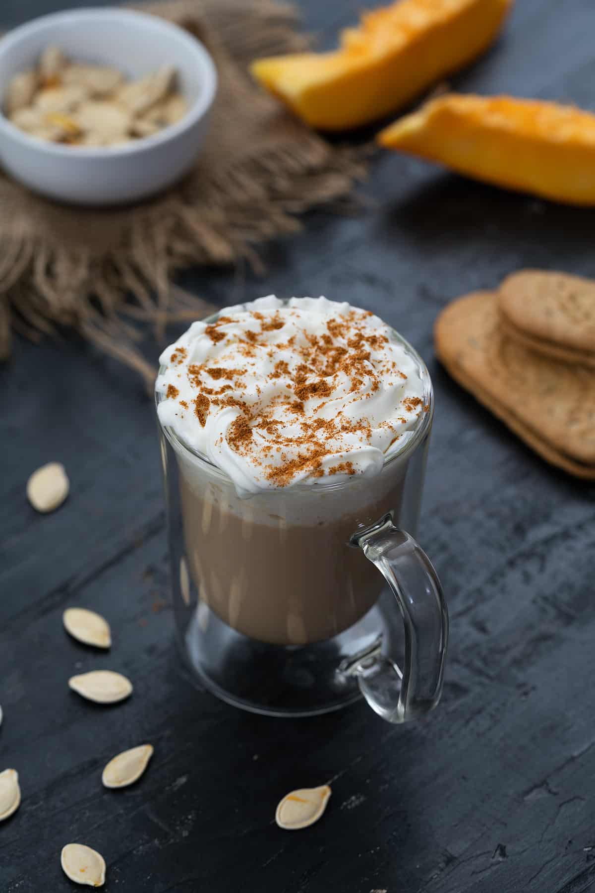 Pumpkin spice Latte served in a mug topped with whipped cream and pumpkin spice powder.