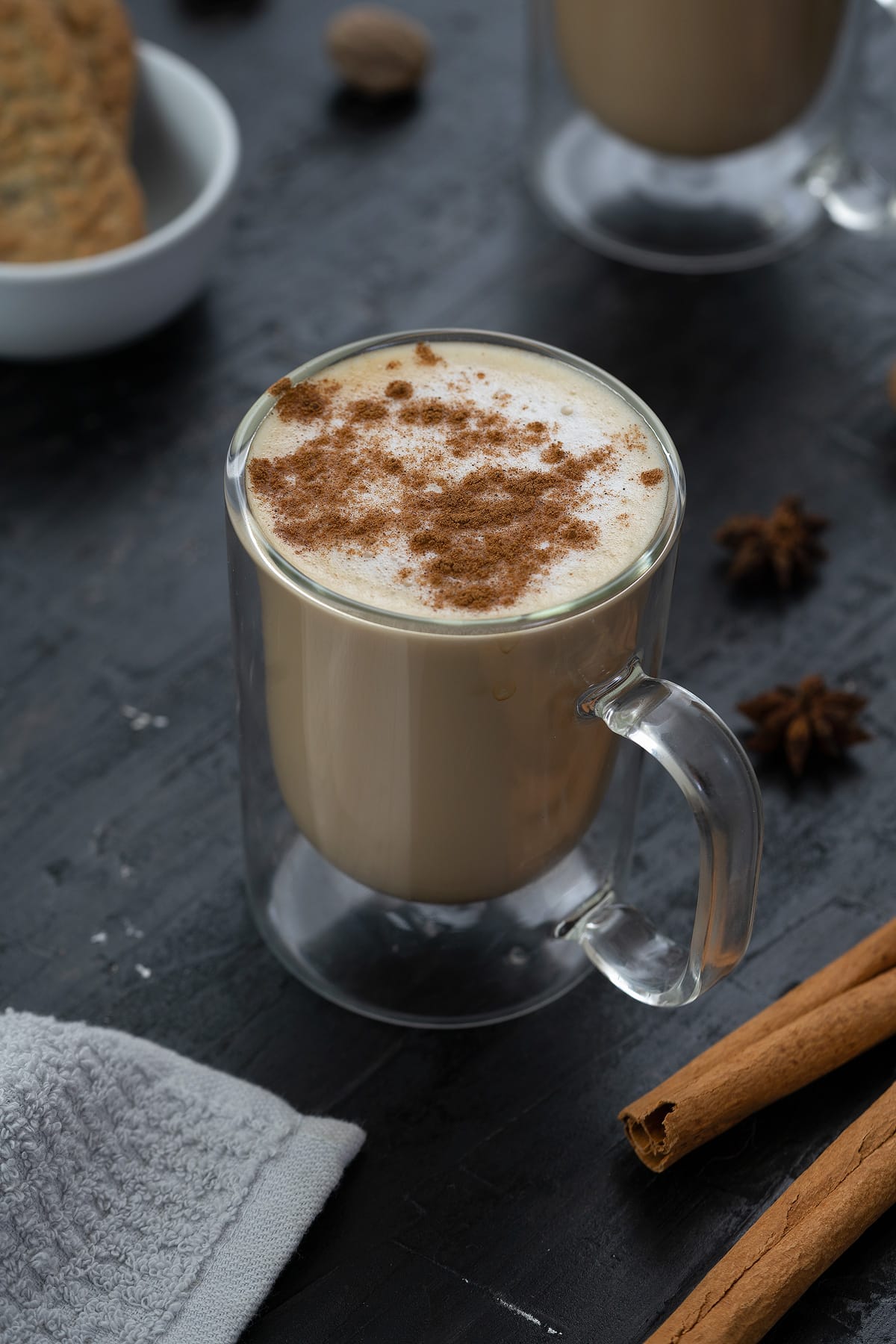 Chai Tea Latte Served in a mug with few spices placed around.
