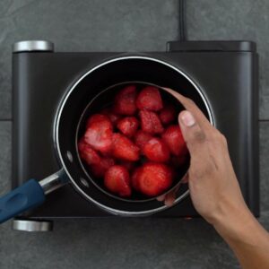 Adding strawberries to pan.