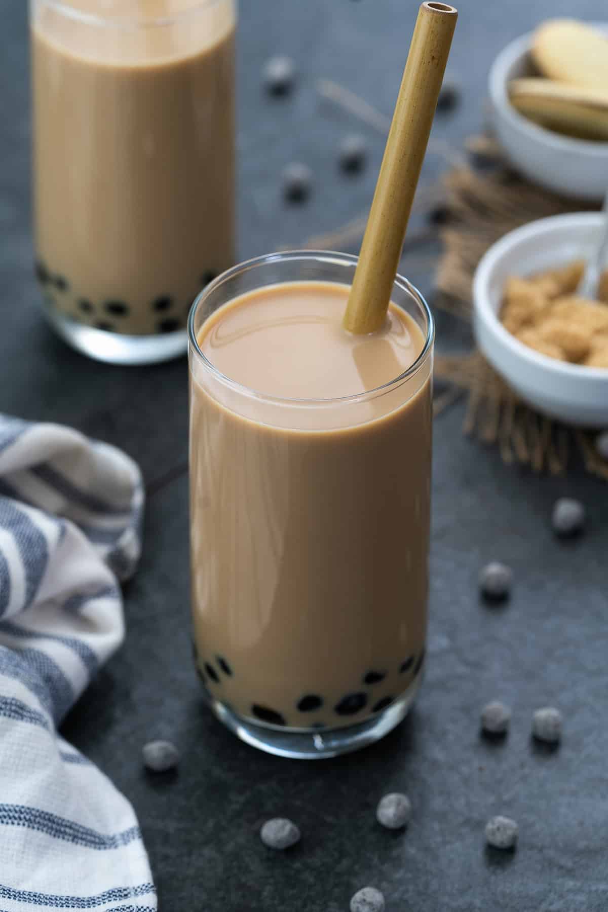 Bubble Tea served in a glass with brown sugar placed in a bowl.