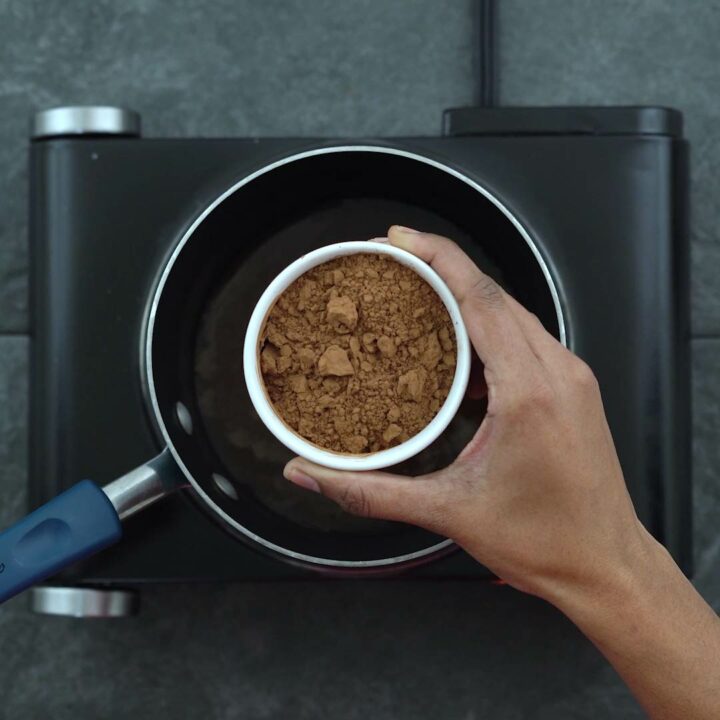 Adding cocoa powder to the saucepan.