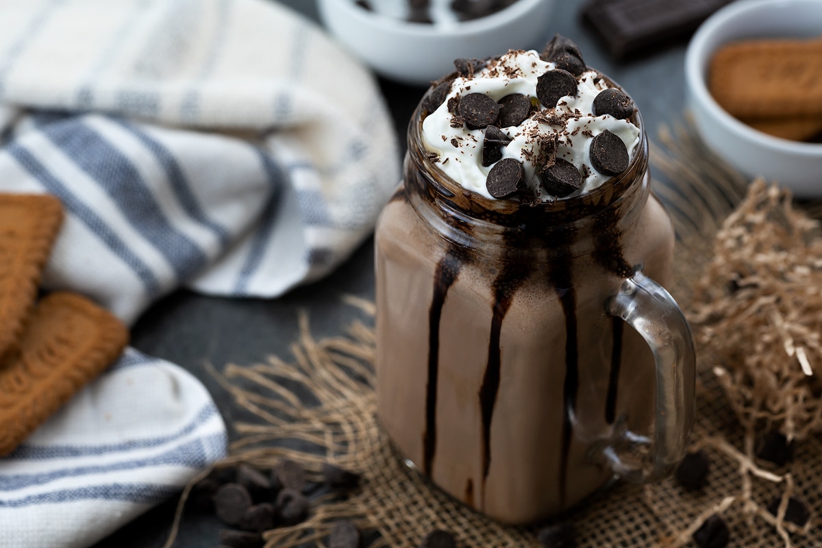 Frozen Hot Chocolate served in a jar topped with whipped cream and chocolate chip.