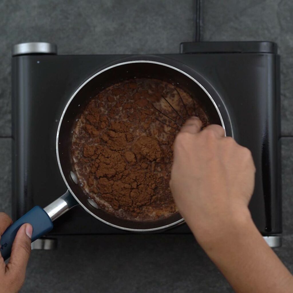 Mixing chocolate chips and cocoa powder to milk.
