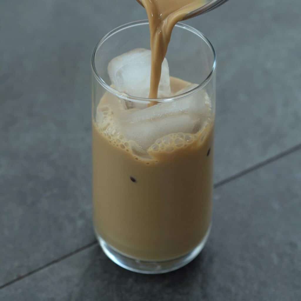 Pouring Vietnamese Coffee over ice cubes.